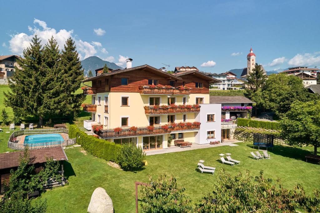 a large building with a yard with a swimming pool at Residence Schiestlhof in Natz-Schabs