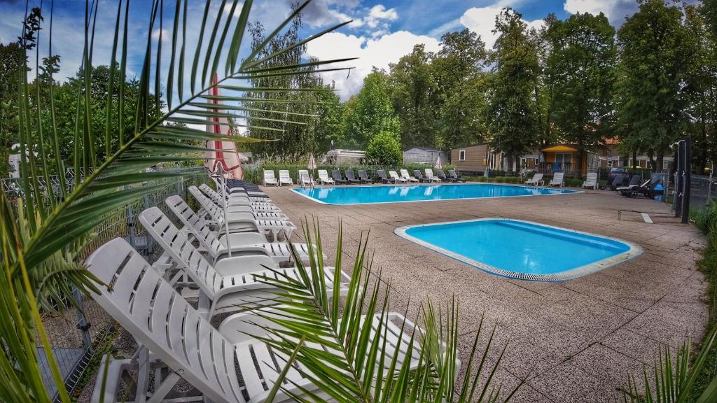 a group of white chairs and a swimming pool at Camping Sokol Praha in Prague