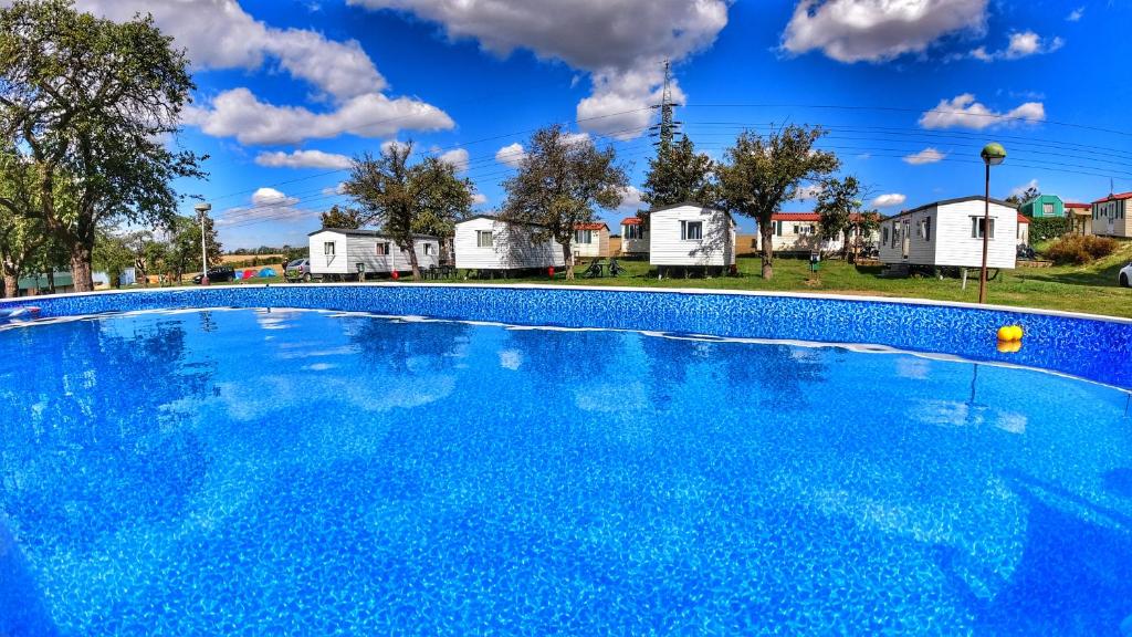 uma grande piscina azul com casas ao fundo em Triocamp Praha em Praga
