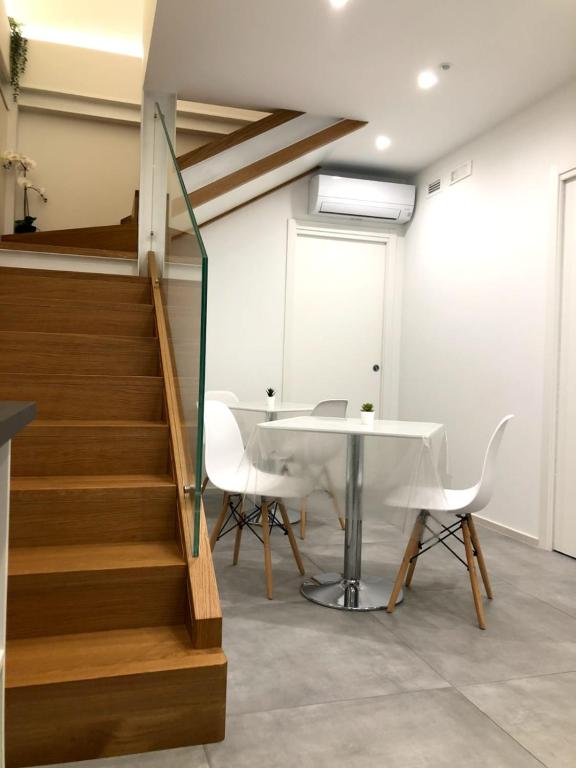 un escalier avec une table et des chaises dans une pièce dans l'établissement President House Matera, à Matera