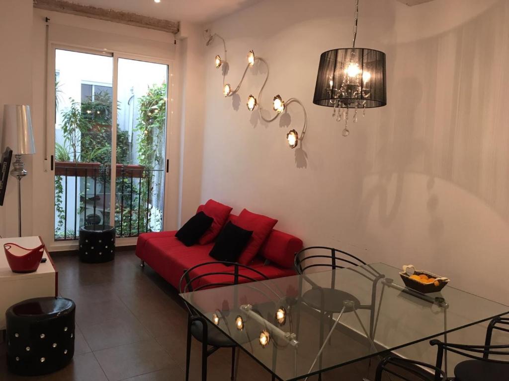 a living room with a red couch and a glass table at Casa Cosy in Valencia