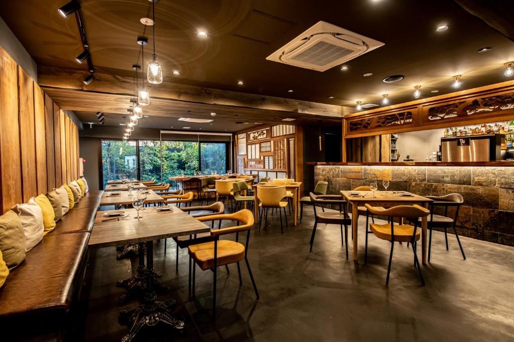 a restaurant with wooden walls and tables and chairs at Hotel Banister Kyoto in Kyoto