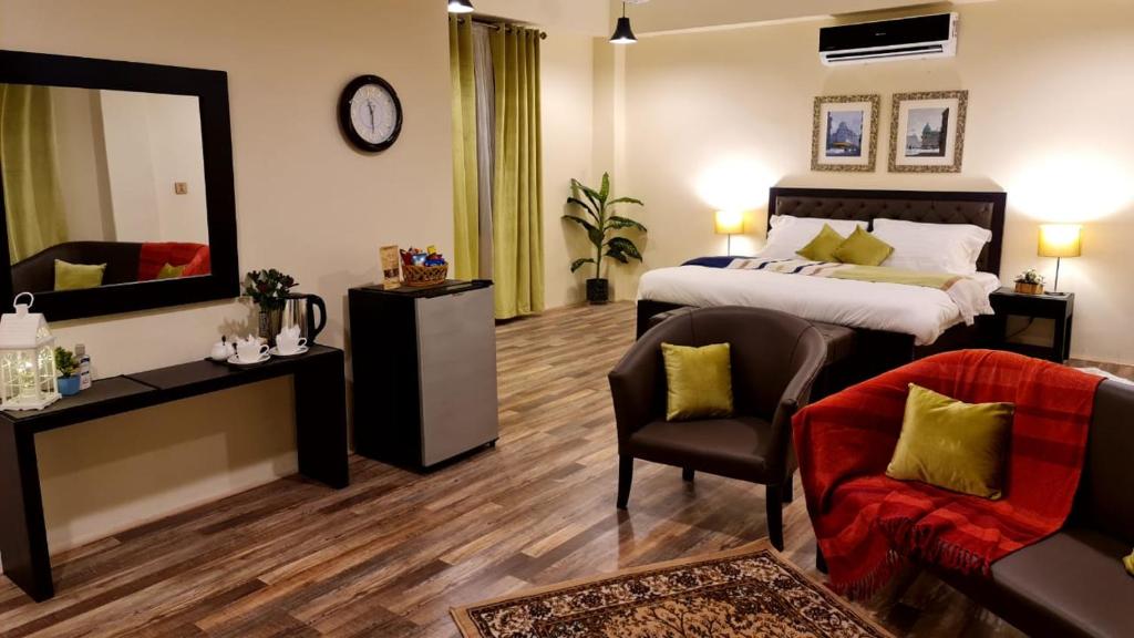 1 dormitorio con cama, silla y espejo en The Mandarin Inn, en Gilgit