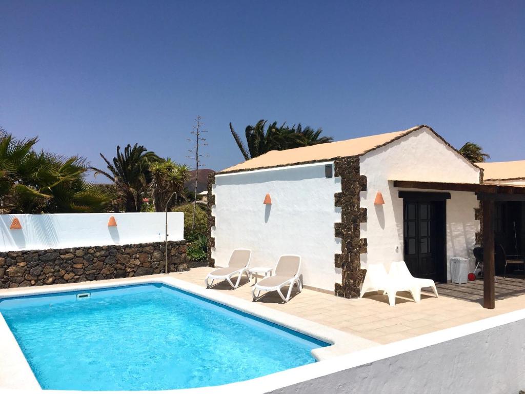 a villa with a swimming pool and a house at Finca Felix Appartement met Private Pool! in Lajares