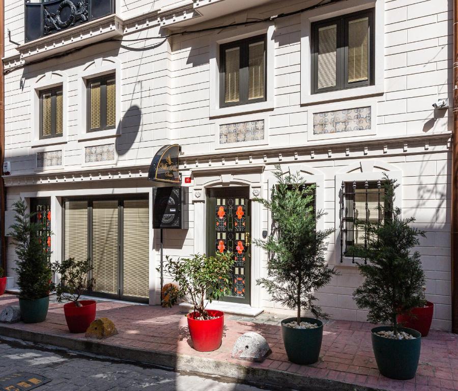 a white building with potted trees in front of it at Villa Pera Suite Hotel in Istanbul