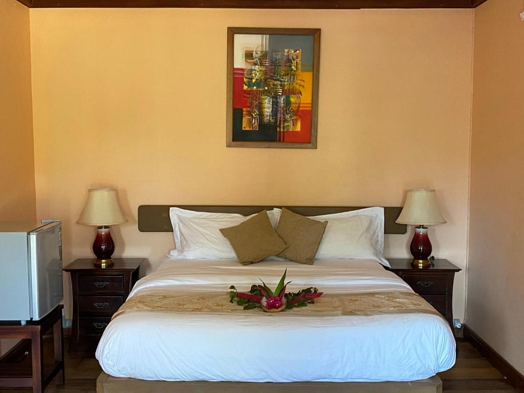 Un dormitorio con una cama con un arreglo floral. en Ocean Lake Tourist Residence en Grand Baie