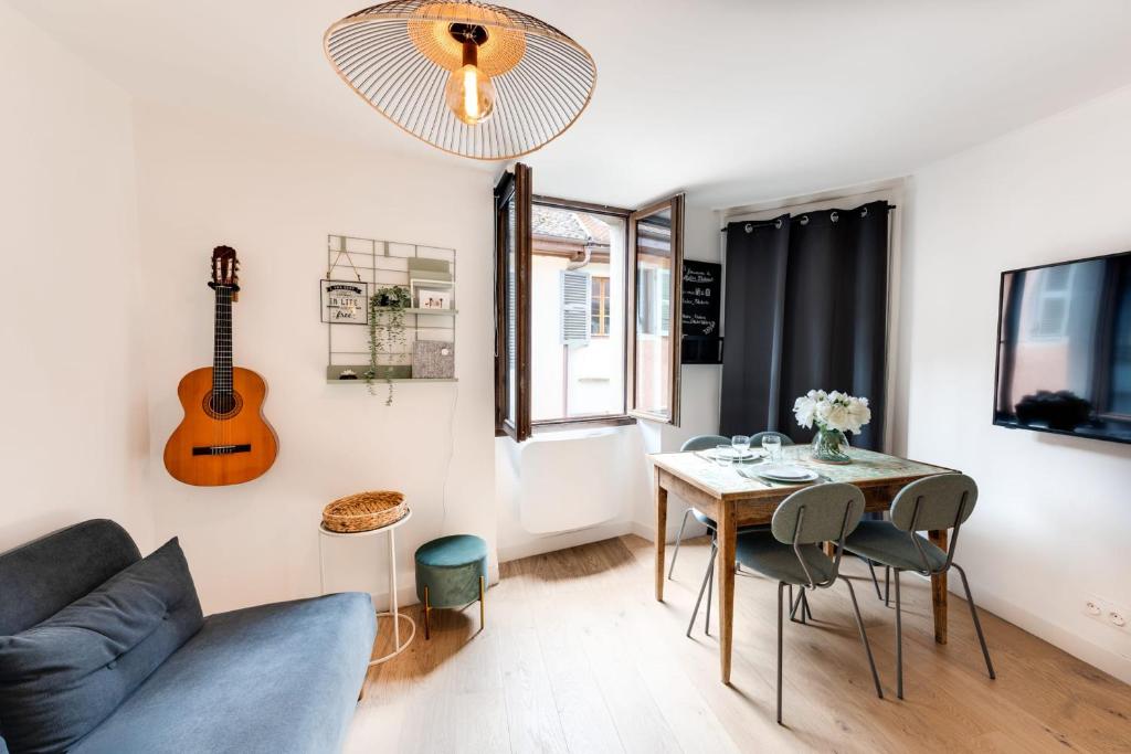 a living room with a couch and a table and a guitar at L'Atelier Filaterie - Apartment for 2 people in Annecy