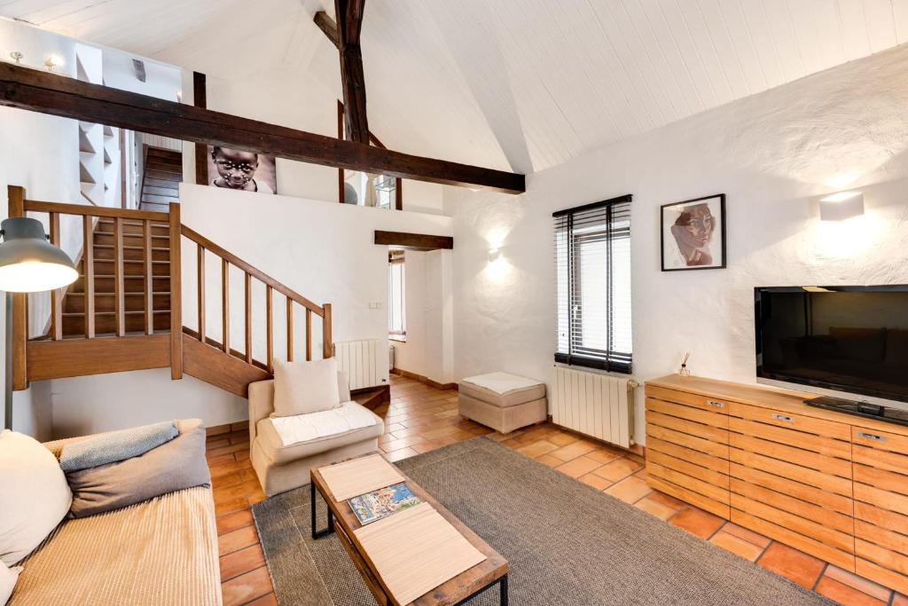 un salon avec un canapé et une télévision dans l'établissement Le Triplex Carnot - Apartment with air conditioning for 5 people, à Annecy