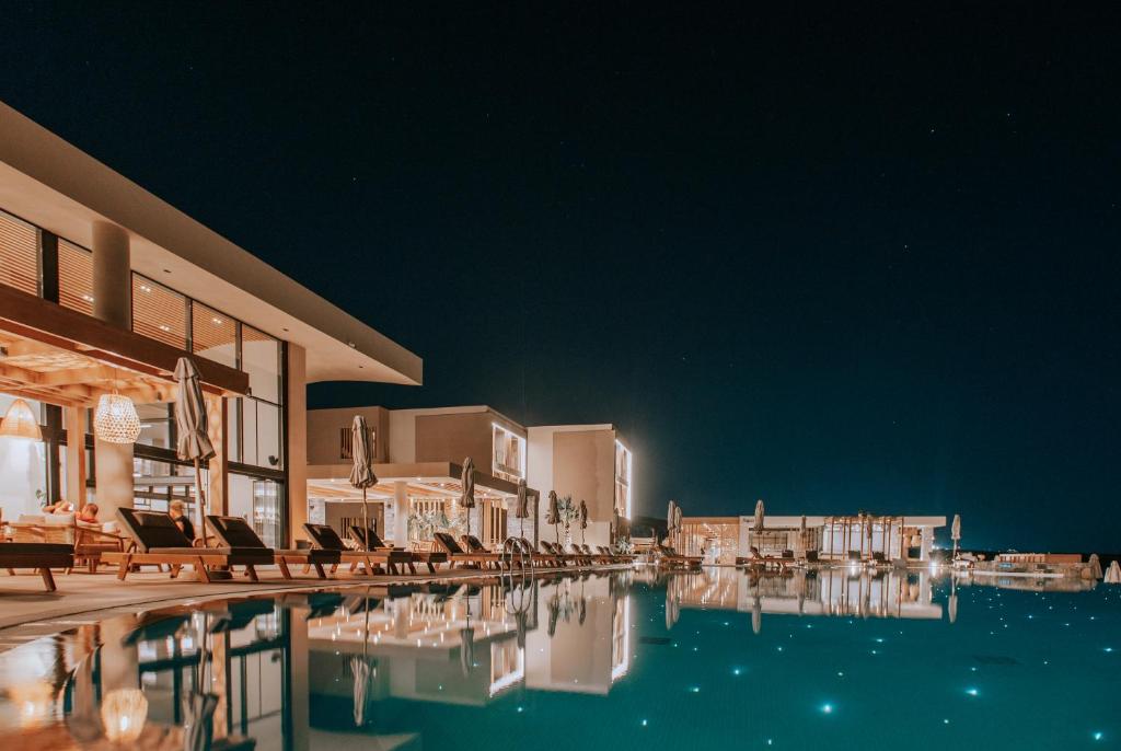 - une piscine dans un complexe la nuit dans l'établissement Unique Blue! Resort and Villas Adults Only, à Karteros