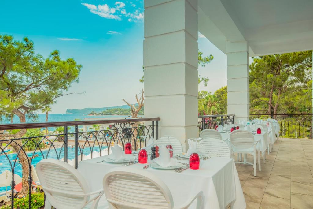 a row of white tables and chairs on a balcony at Sherwood Exclusive Kemer - Kids Concept in Kemer