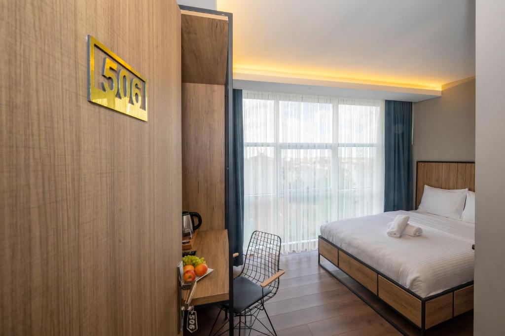 a hotel room with a bed and a window at Çorlu Dem Hotel in Çorlu