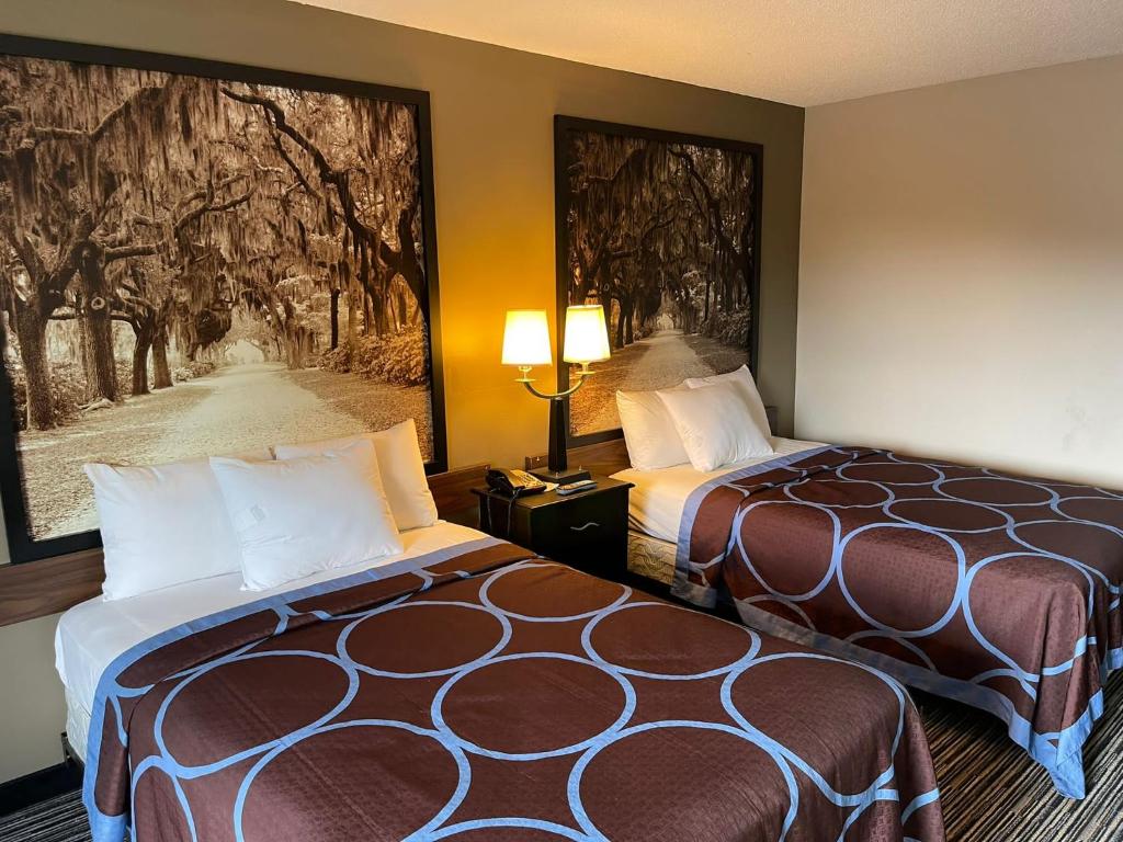 a hotel room with two beds and a painting on the wall at Super 8 by Wyndham Elberton in Elberton