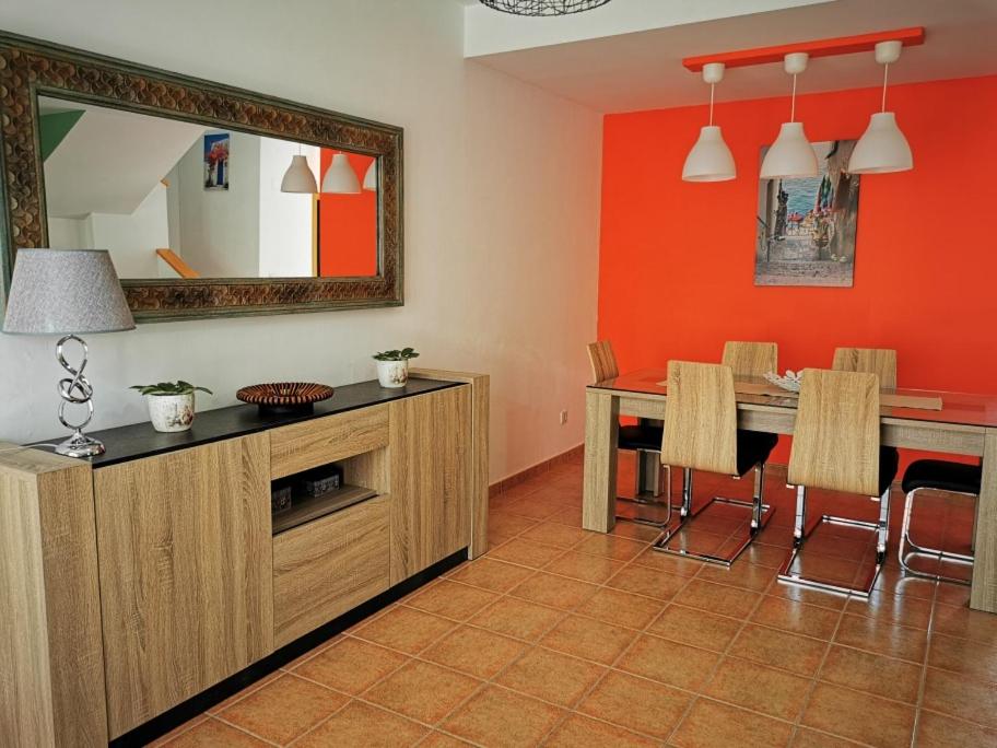 a dining room with a table and a mirror at Cosy duplex in Agaete with WIFI in Agaete