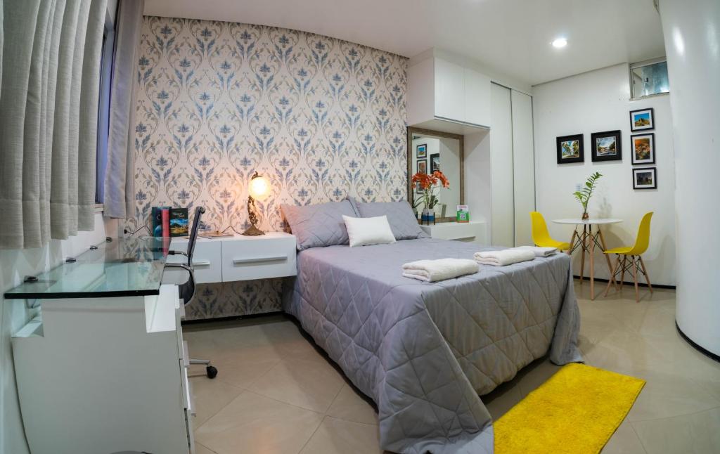 a bedroom with a bed and a glass table at Flat da Vila in Viçosa do Ceará