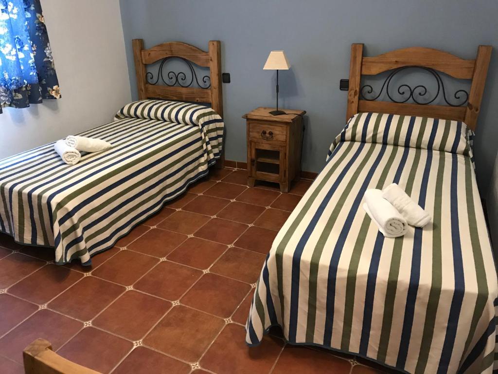 2 camas num quarto com piso em azulejo em La venta el Membrillo em Membrío