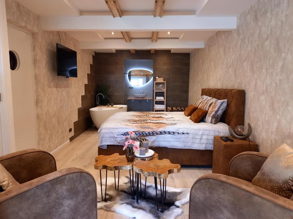 een slaapkamer met een groot bed en een badkamer bij Suite Pura Vida in Oud-Ade