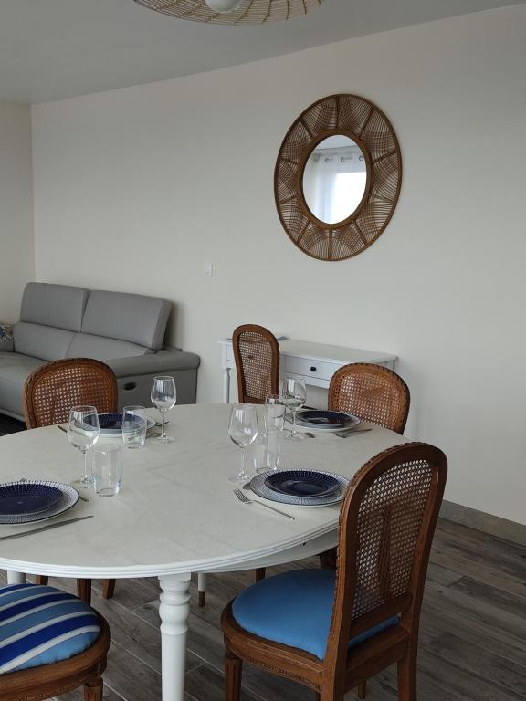 - une table à manger avec des chaises et un miroir dans l'établissement Au repos des baigneurs, appartement rez-de-chaussée, WIFI, au Tréport