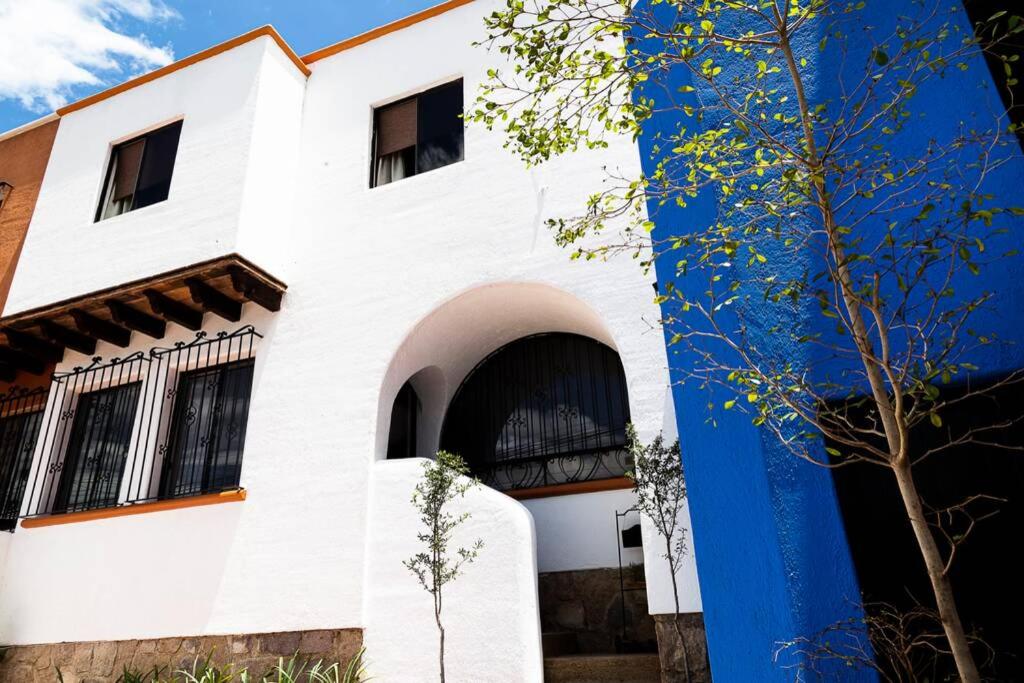a white building with a blue wall at Casa Aurora, estilo rústico-moderno, Guanajuato in Guanajuato