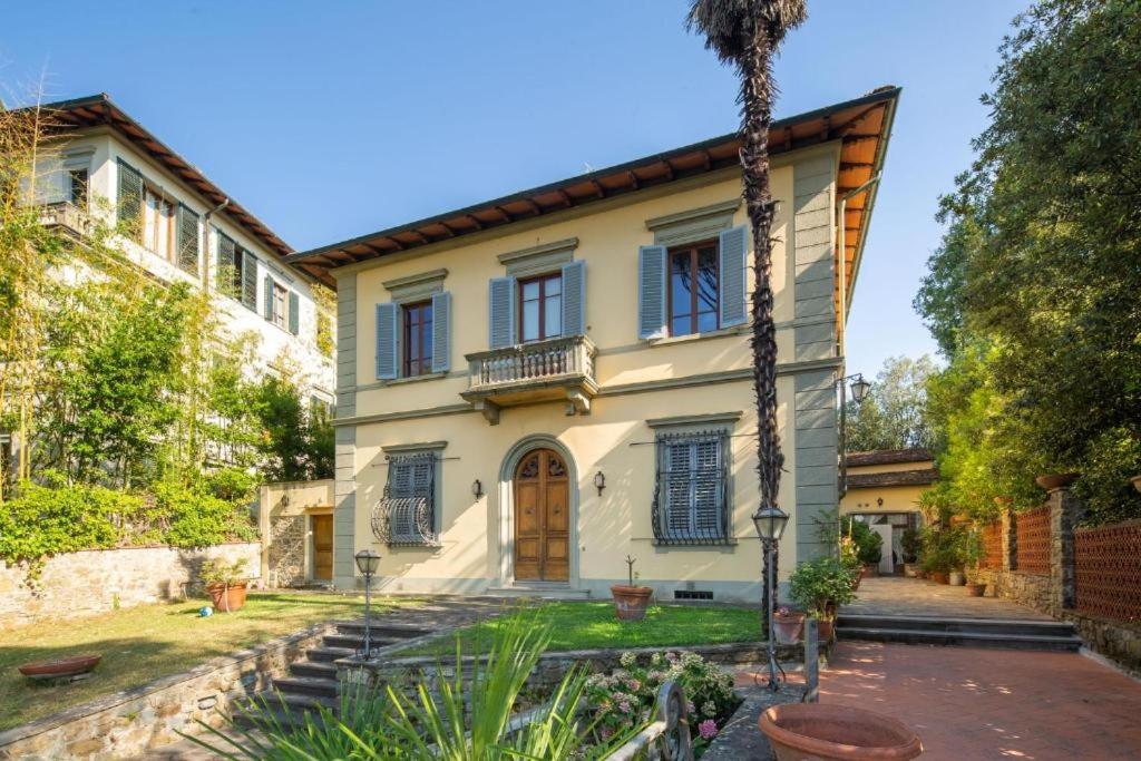 uma casa com uma palmeira em frente em Villa Lia - Apartment in Villa with private garden and Pool em Florença