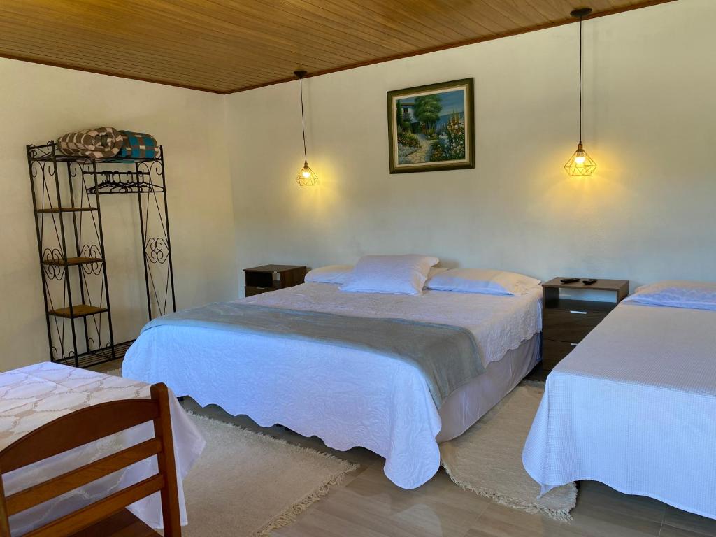 1 dormitorio con 2 camas y 2 luces en Chalés Sonho Meu Com Cozinha, en Visconde De Maua