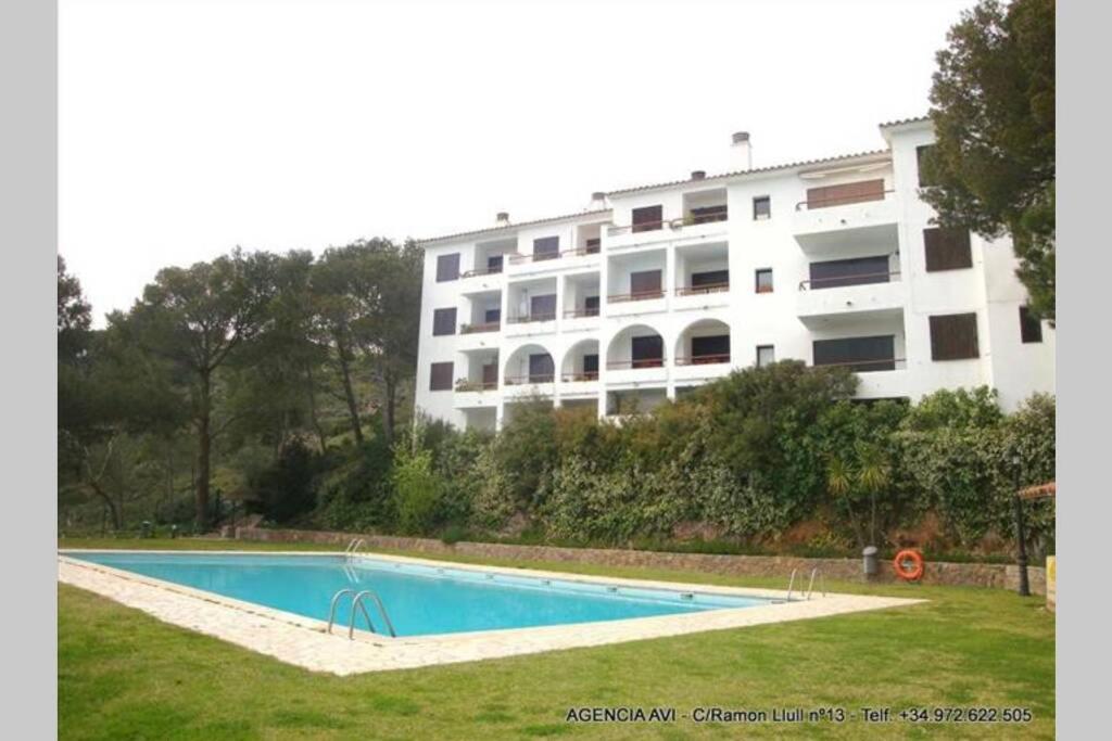 un edificio con piscina frente a un edificio en APT. CON VISTAS ISLAS MEDAS, en Girona