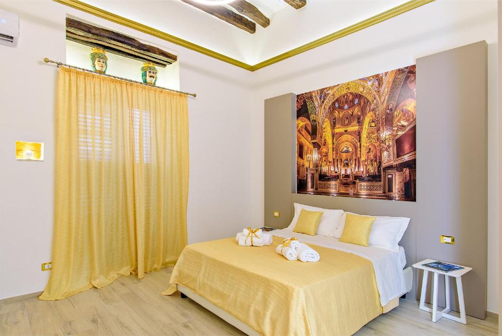a bedroom with a bed with a painting on the wall at Barlaman Luxury Rooms in Palermo