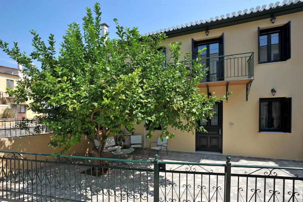 una casa con un árbol delante de una valla en Giannitsa's House, en Galaxidhion