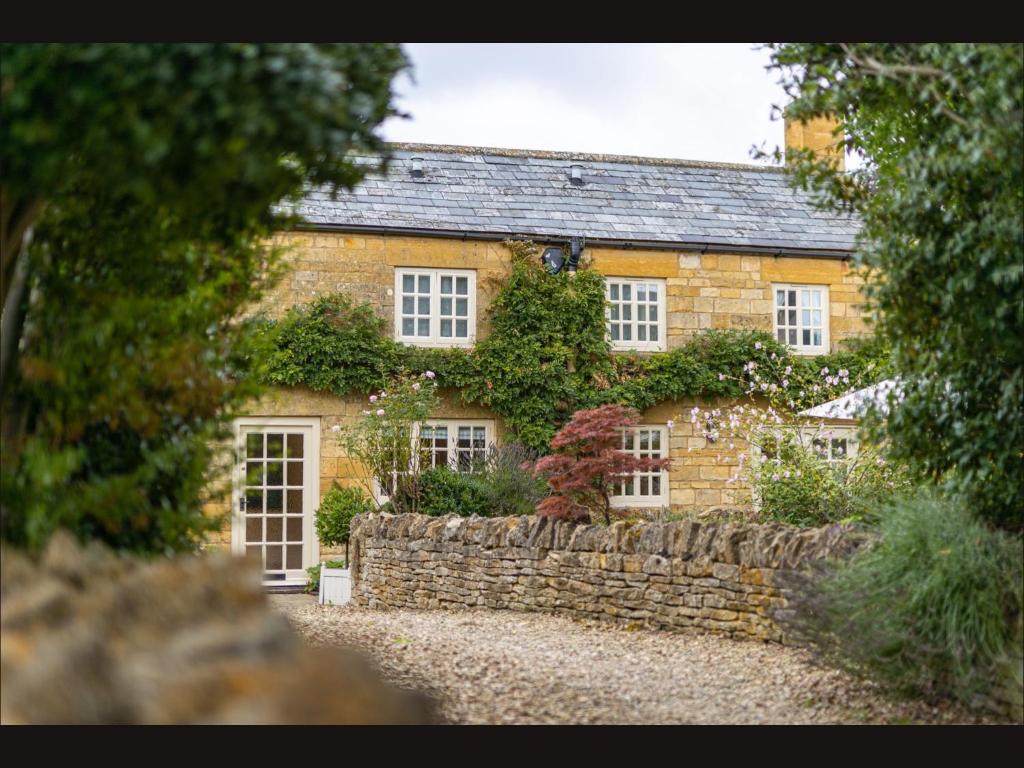 an old brick house with a stone wall at Wisteria Cottage , Pretty Cotswold Cottage close to Chipping Campden in Weston Subedge