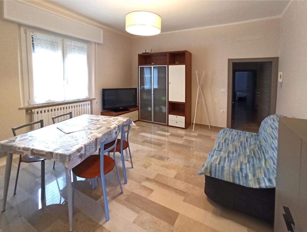 een woonkamer met een tafel en stoelen en een televisie bij Appartamento Dolcefarniente in Lucrezia