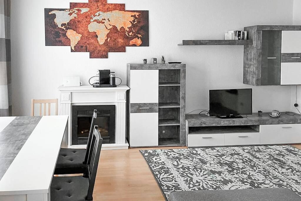 ein Wohnzimmer mit einem Tisch, einem TV und einem Kamin in der Unterkunft Zentral, ruhig, 4Personen, Balkon, Waschmaschine in Chemnitz