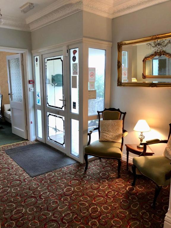 a living room with a chair and a sliding glass door at Bryn Noddfa in Morfa Nefyn