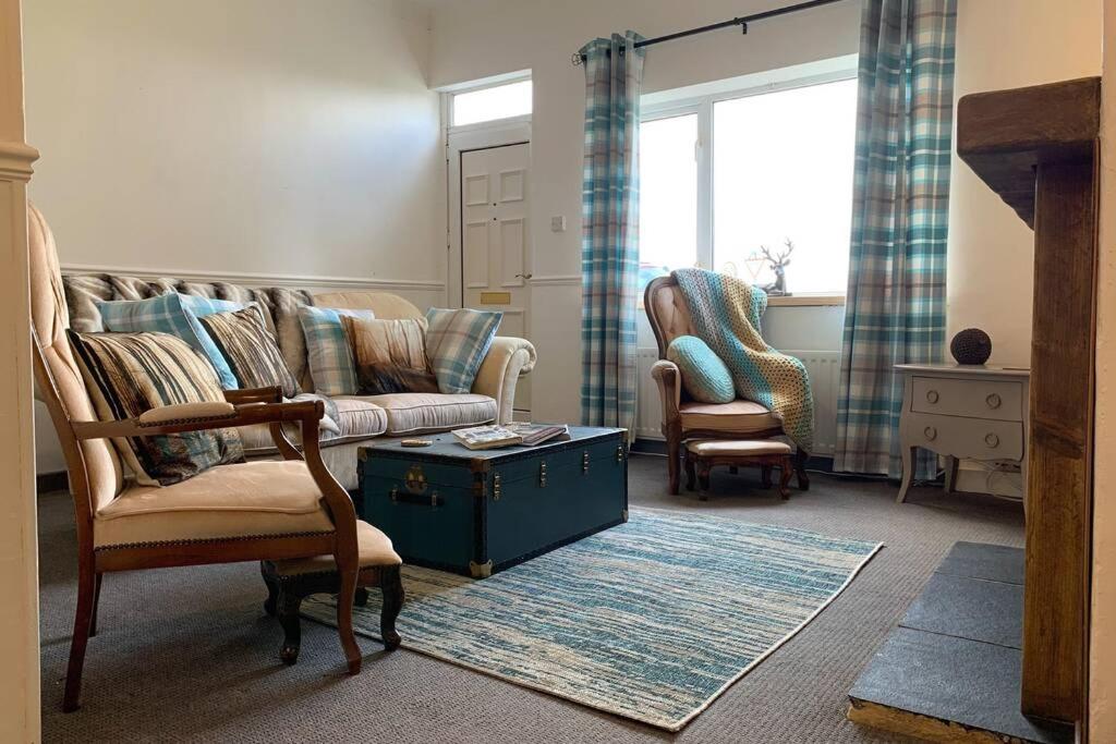 a living room with a couch and two chairs at Cosy cottage near Saltburn & Whitby in Boosbeck