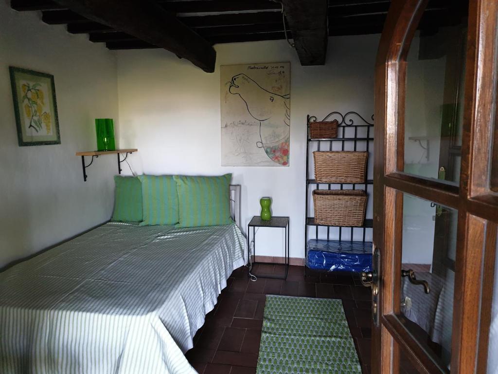 sypialnia z łóżkiem z zielonymi poduszkami w obiekcie Le Querciolaie Monte Cavallo - entire house w mieście Saturnia