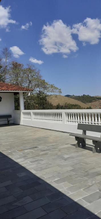 un banco blanco sentado frente a un edificio en Pousada Pedacinho do Céu -Chalé Familia, en Cunha
