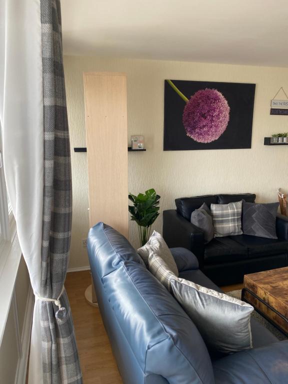 a living room with a leather couch and a table at CyCy Apartment 2 in Aberdeen