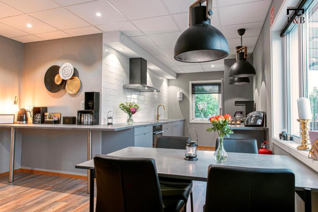 a kitchen and dining room with a table and chairs at Thunor B&B in Skellefteå