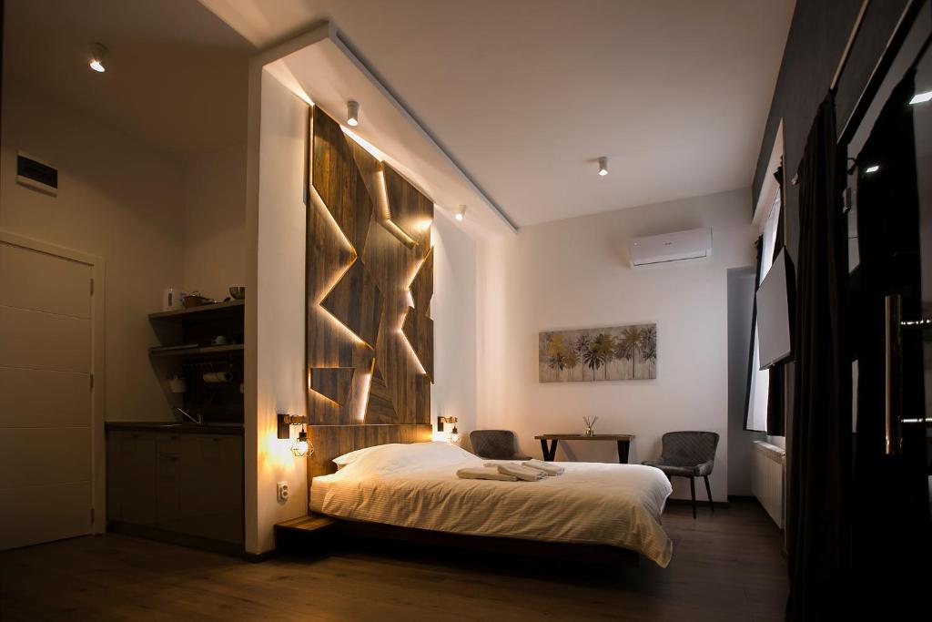 1 dormitorio con 1 cama con una pared grande en East & West Apartments, en Belgrado