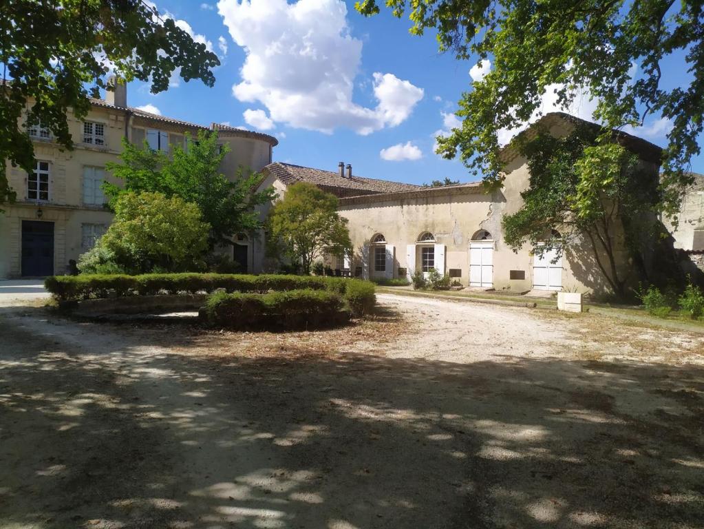 an old house with a driveway in front of it at Gîte de l'orangerie du Château de la Bégude de Mazenc in La Bégude-de-Mazenc