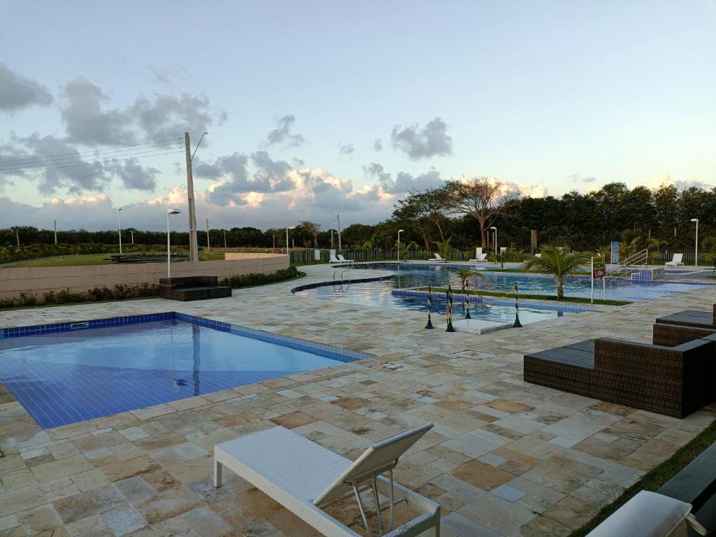 una gran piscina con sillas y avisorvisor en Casa alto padrão com piscina em Condomínio Fechado, en Barra de São Miguel