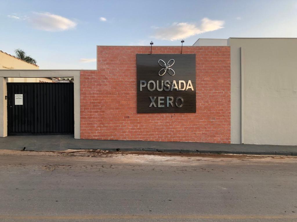 a sign on the side of a brick building at Pousada Xero in Capitólio