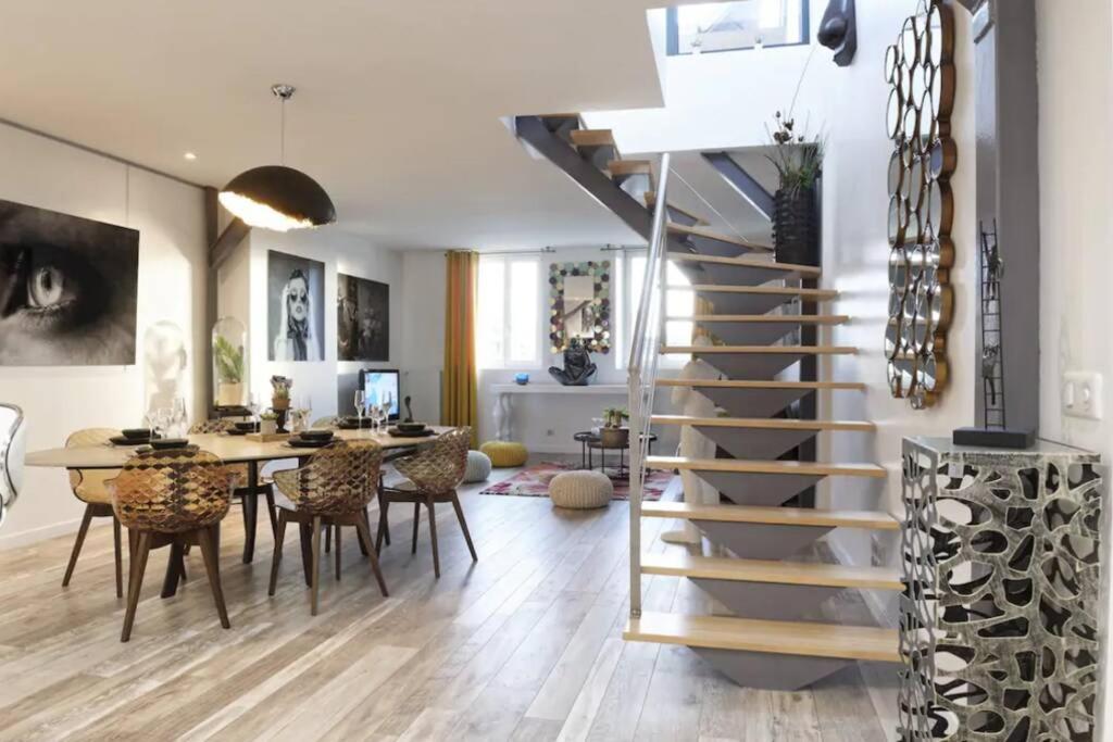 un salon avec un escalier et une salle à manger dans l'établissement Reims Centre : appartement lumineux et atypique 46, Place d'Erlon, à Reims