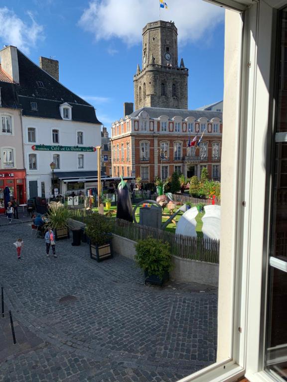 ein Gebäude mit einem Uhrturm in einer Stadt in der Unterkunft Le cottages des remparts - le lodge in Boulogne-sur-Mer