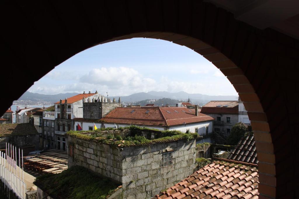 a view of a city through an arch of a building at Apartamentos Turísticos Casa Soto in Baiona