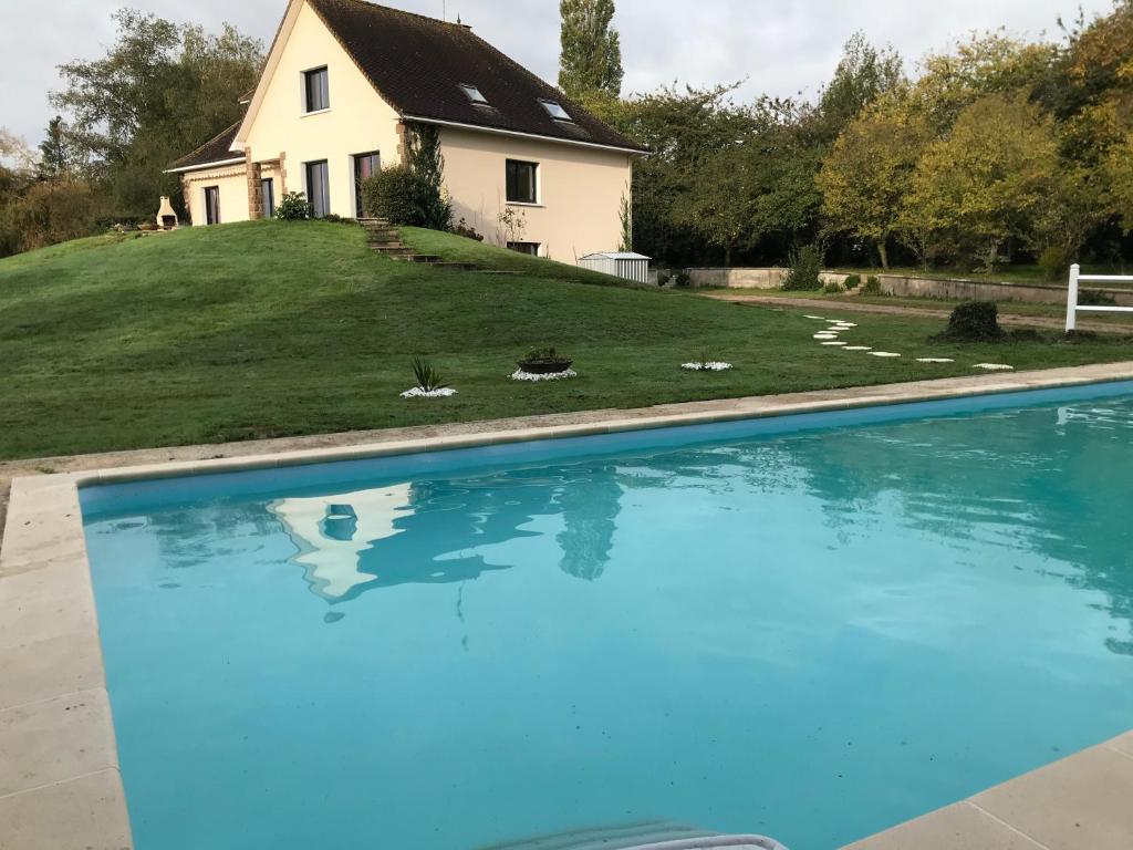 a house and a swimming pool in front of a house at Le pain perdu de germaine in Château-Gontier