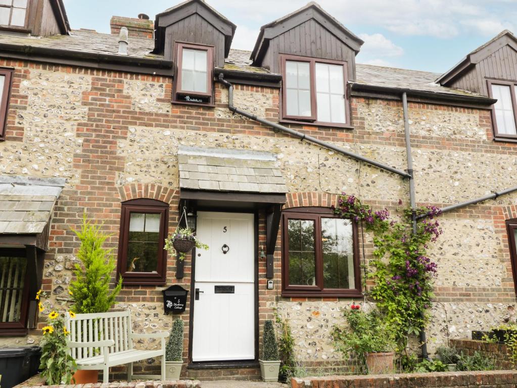 Casa de ladrillo con puerta blanca y ventanas en Blueberry Cottage, en Dorchester