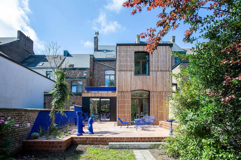 a wooden house with a patio in front of it at Island in Island, B&B boutique, Design et Vintage in Namur