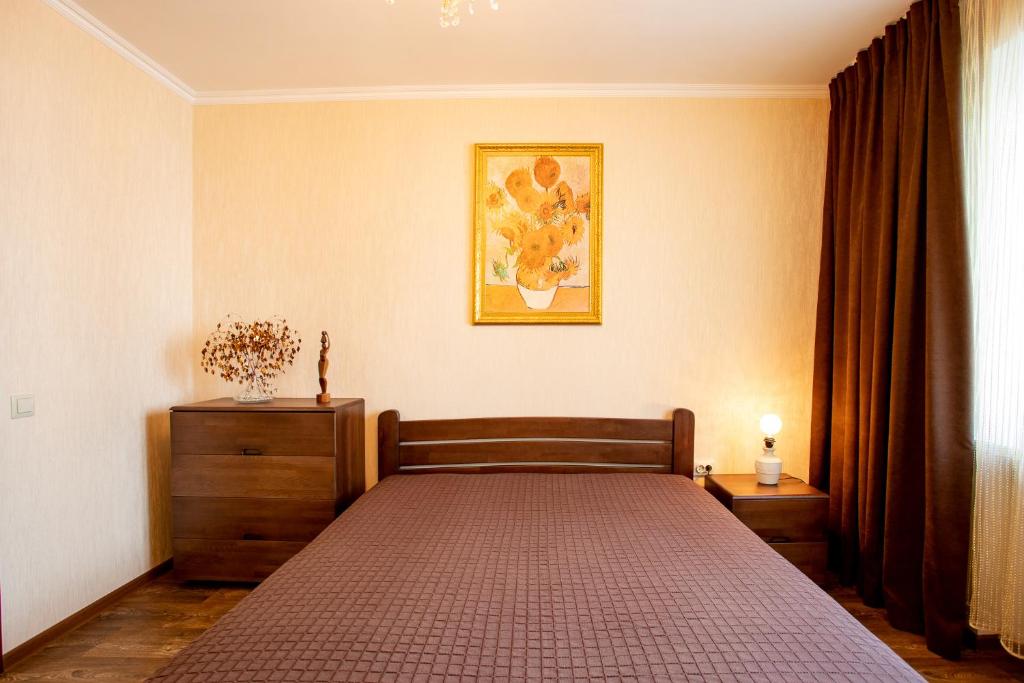 um quarto com uma cama e uma fotografia na parede em City Center. Central Avenue. Luxury. em Kherson