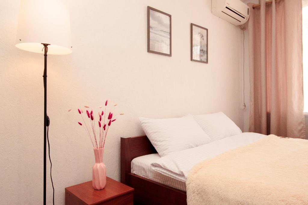 Un dormitorio con una cama y un jarrón con flores. en APARTMENT on Sobornyi Avenue 61 en Oleksandriya