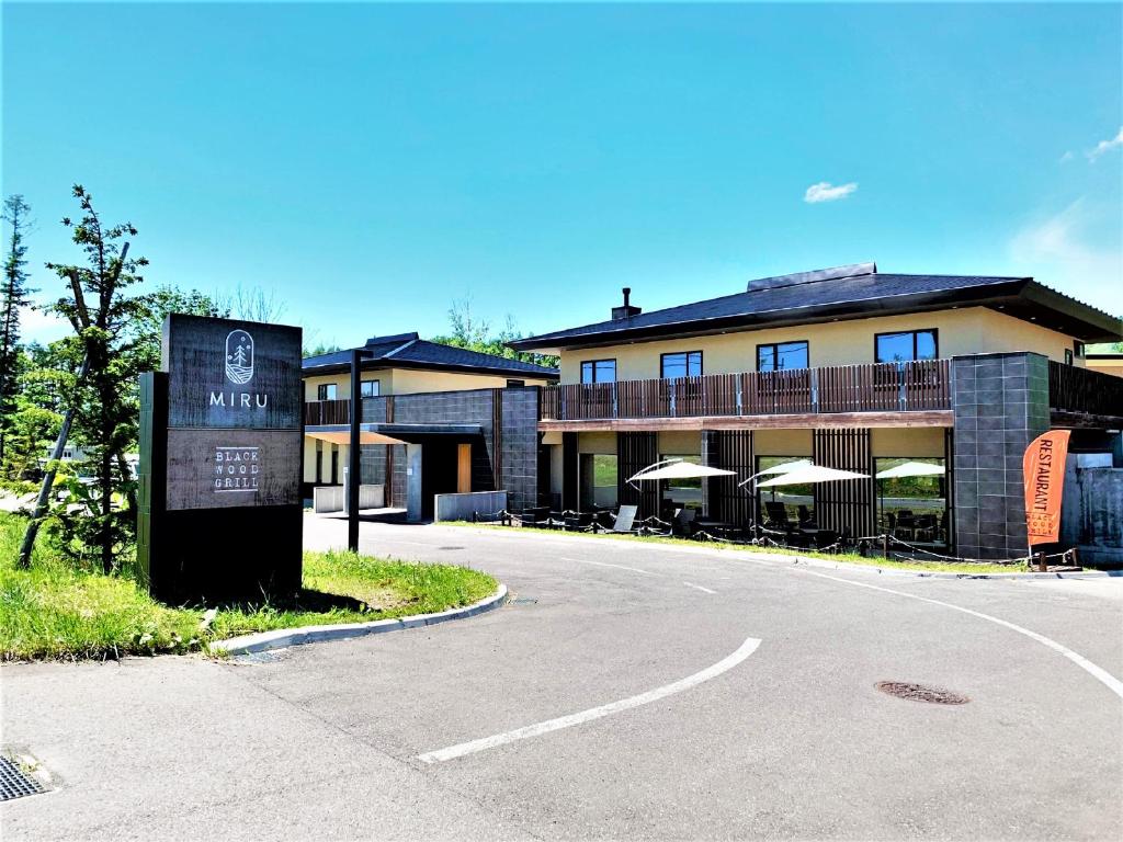 un edificio con una señal junto a una carretera en Miru Niseko, en Niseko