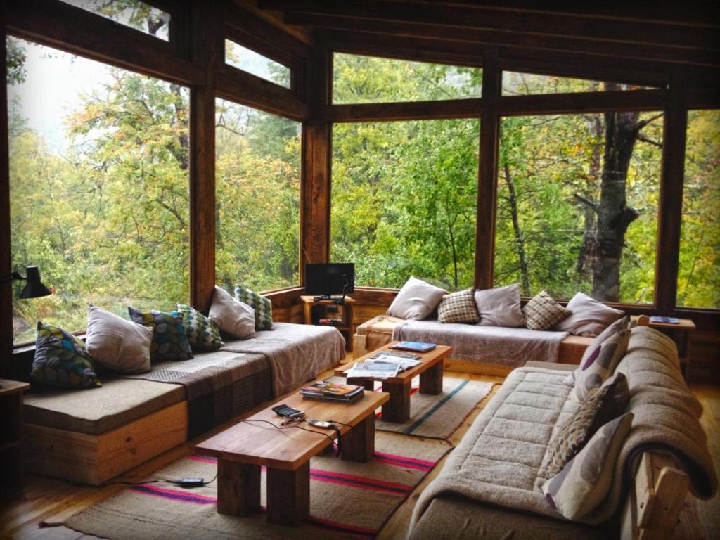 a living room with couches and a large window at Onai Hostel in Las Trancas
